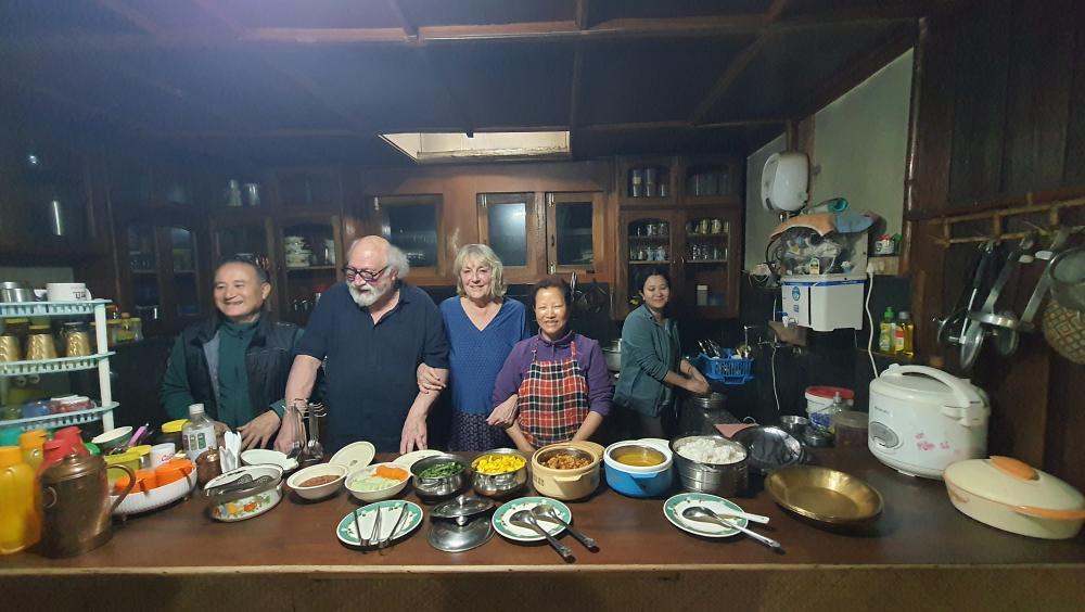 Diminque and Jeans Pierre sharing a meal with a host family in a traditional Arunachal Pradesh home