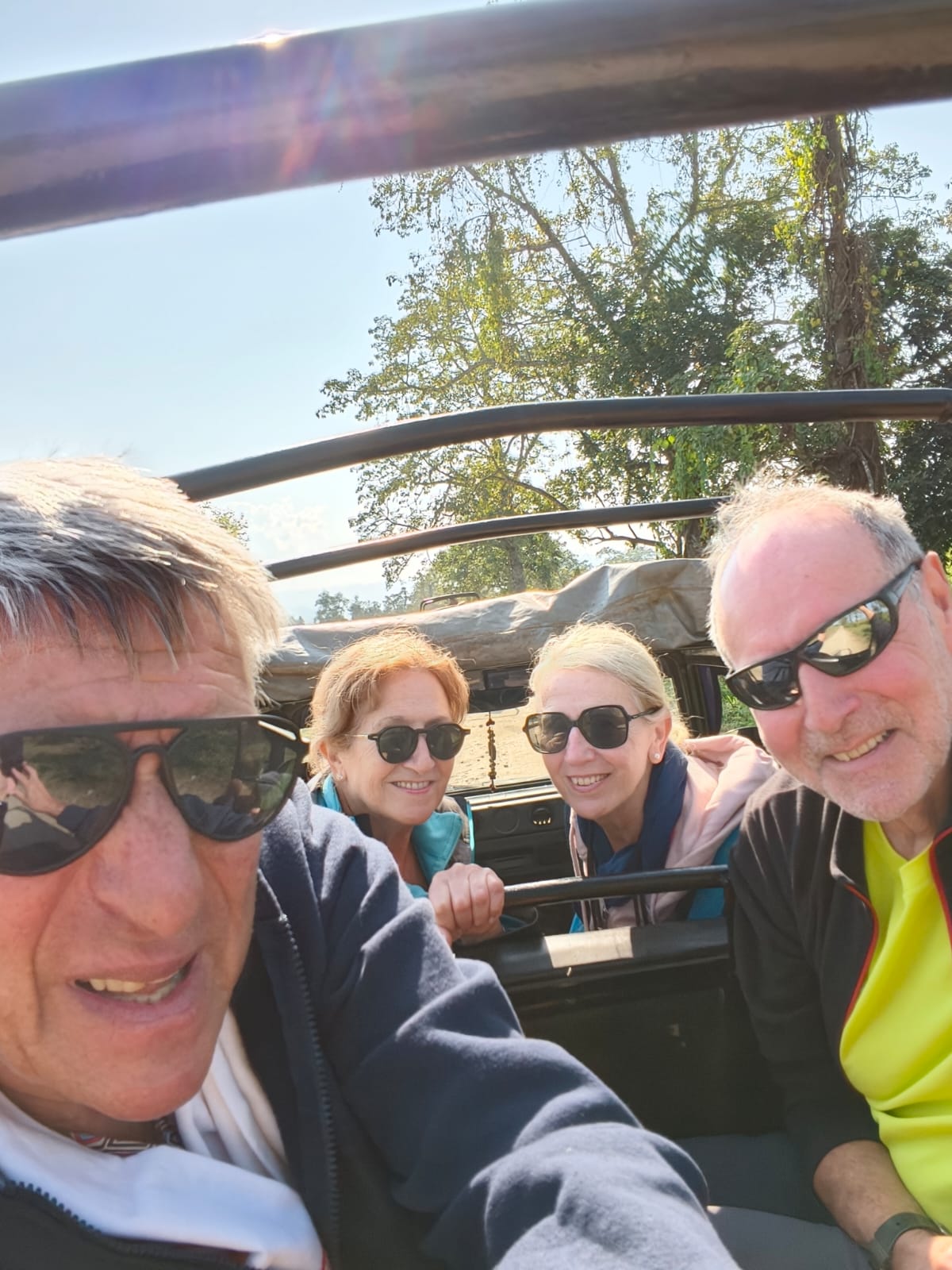 Four travellers in an open safari jeep in Kaziranga National Park, Assam, early in the morning
