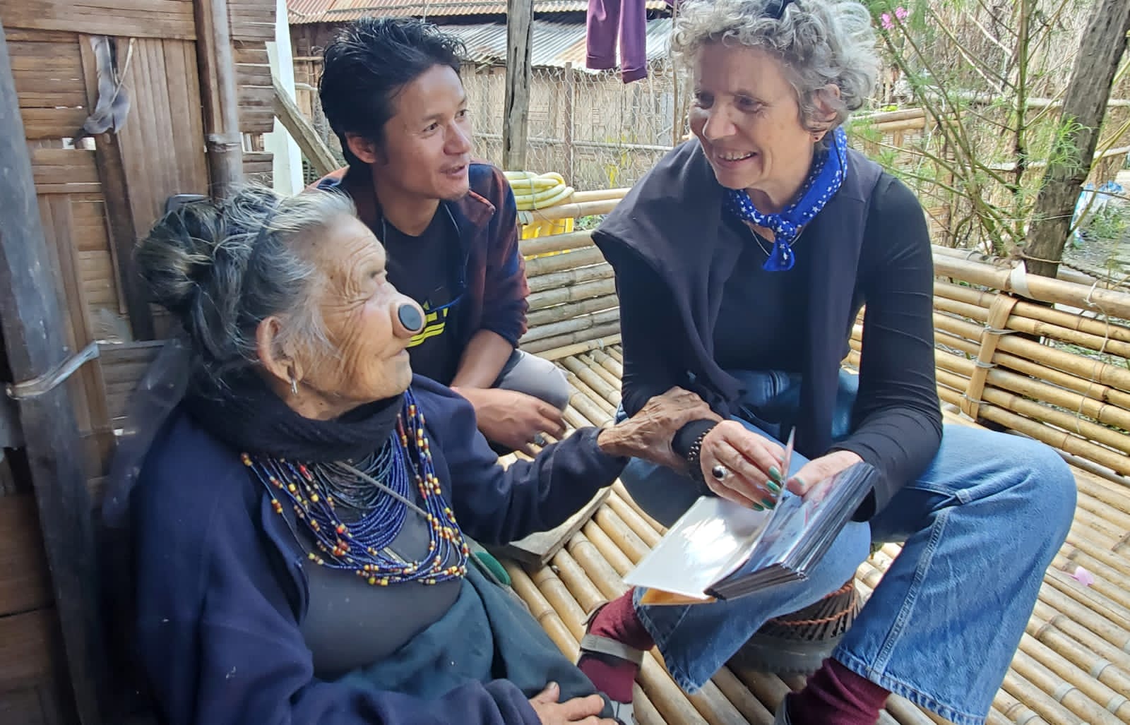 Odile in conversation with an elderly Apatani woman wearing nose plugs and bead necklaces in Ziro Valley