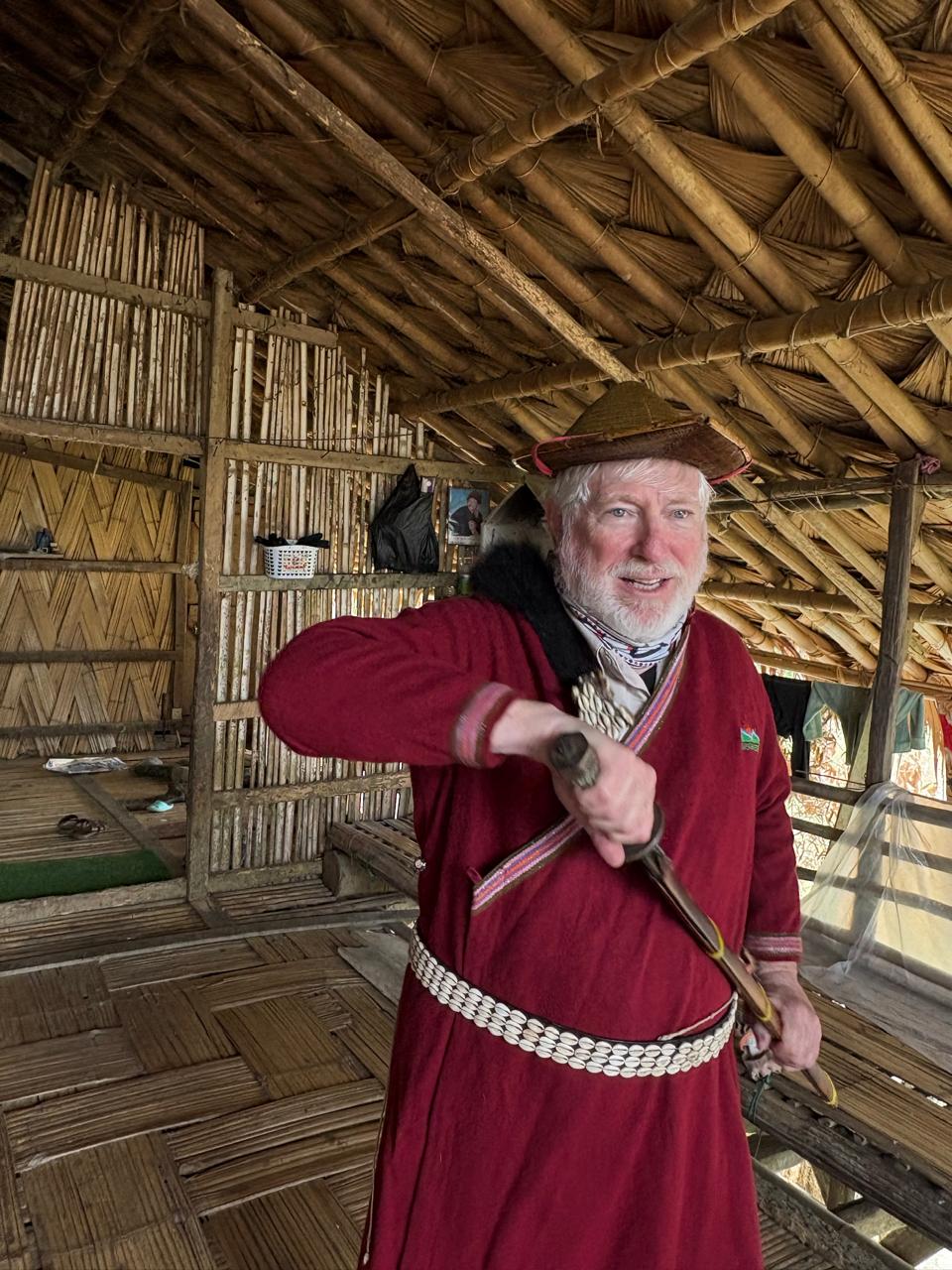 A guest in traditional Arunachali ceremonial attire inside a bamboo home