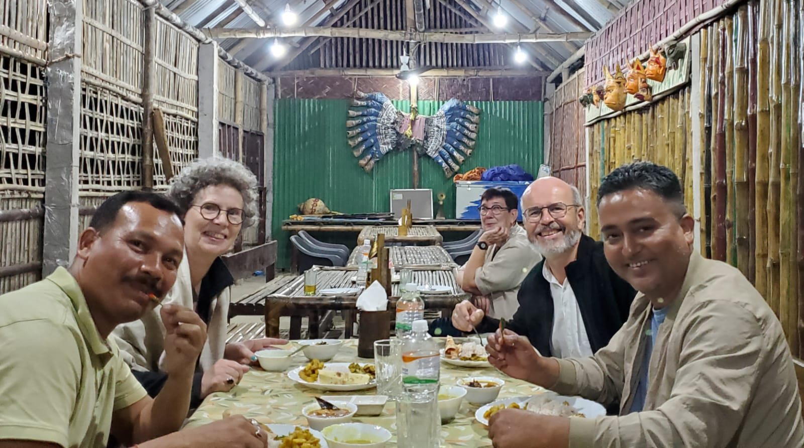 Robert, Odile, guide Pradeep and driver Basumutary at dinner in a bamboo dining hall in Assam