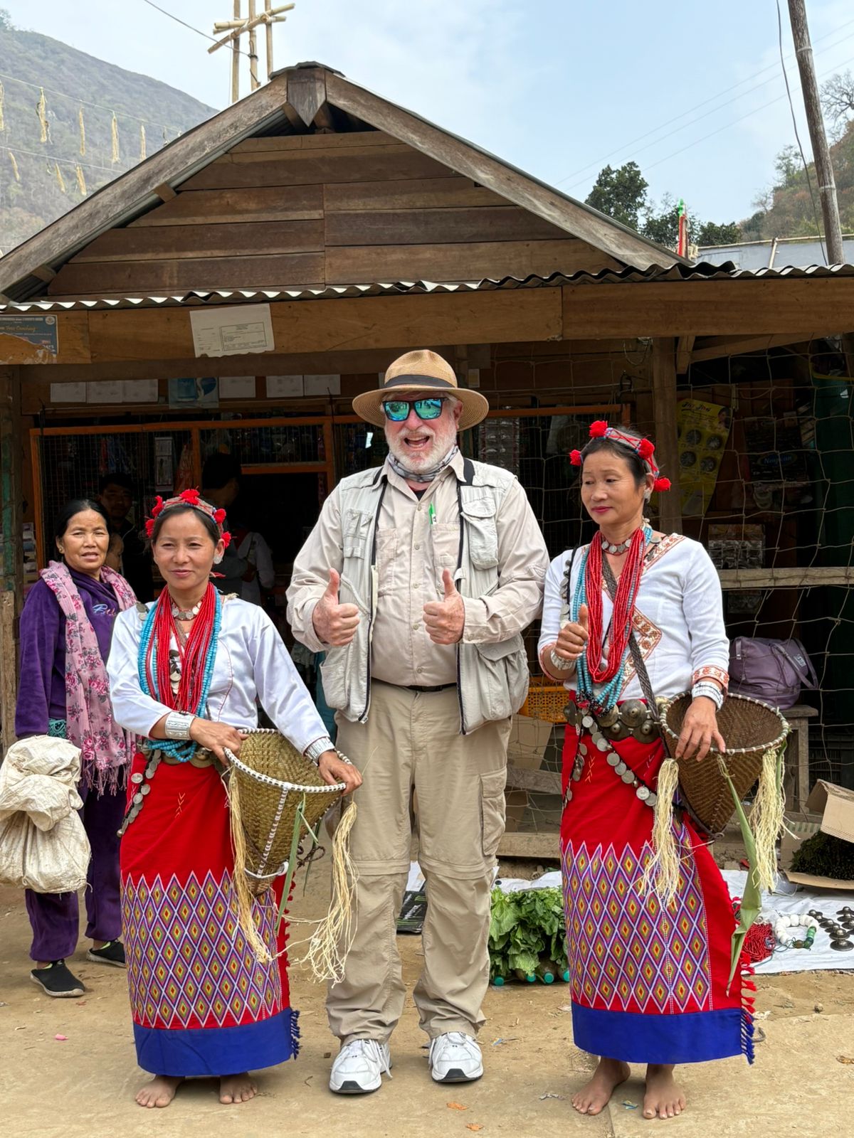 George Lowe with Apatani women in traditional dress outside a village shop in Arunachal Pradesh