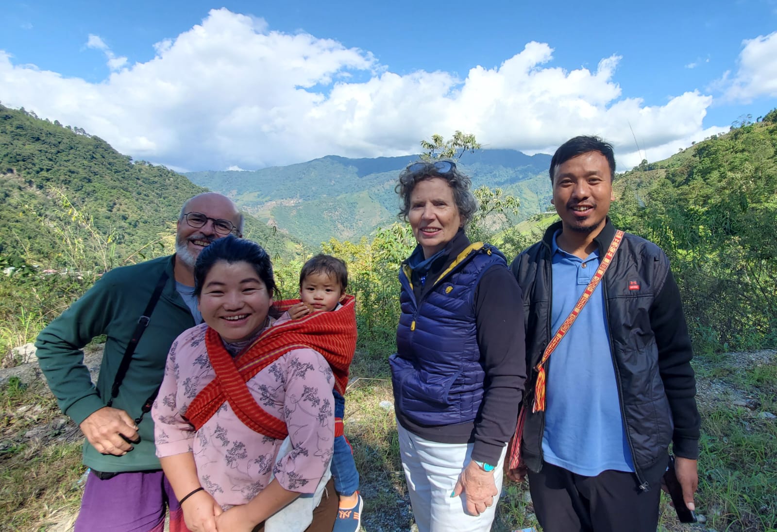 Robert and Odile with a young Apatani mother carrying her child and their guide on a forested ridge