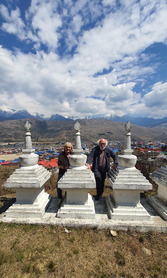 Diminque and Jeans Pierre among white Buddhist stupas overlooking Mechuka Valley